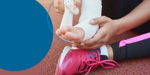 A track runner wrapping her foot in gauze on the track